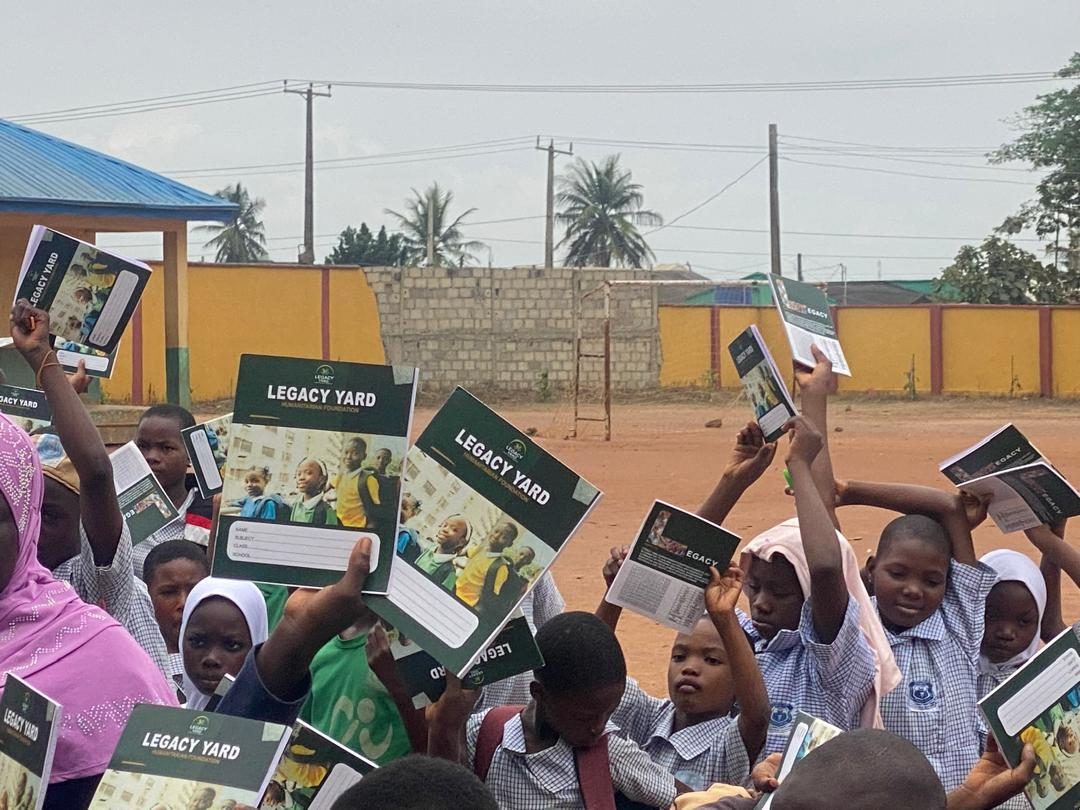 Close view of Legacy Yard exercise books held up by pupils